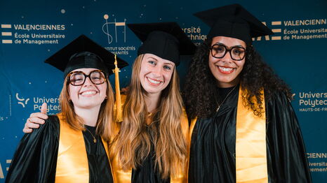 Trois diplômées posent devant le photocall lors de la cérémonie de remise de diplômes