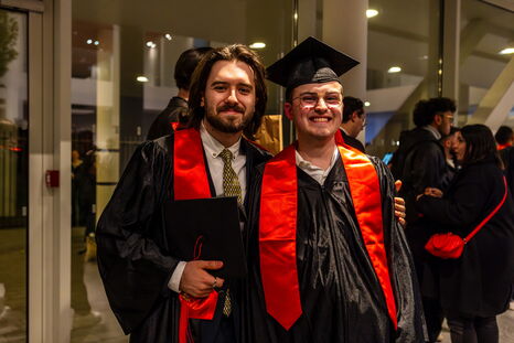 Deux diplômés posent fièrement avec leur diplôme officiel