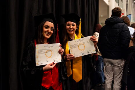 Deux diplômées posent fièrement avec leur diplôme officiel