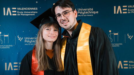 Deux diplômés posent devant le photocall lors de la cérémonie de remise de diplômes