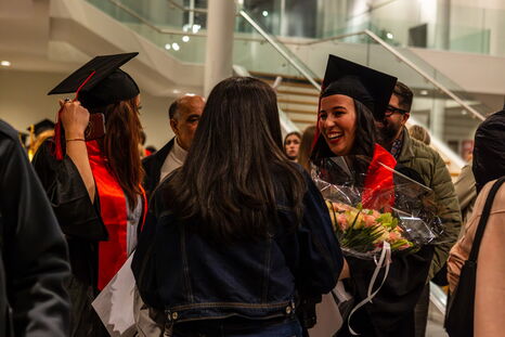 Une diplômée reçoit un bouquet de fleurs de ses proches