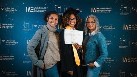 Une diplômée et ses proches posent devant le photocall lors de la cérémonie de remise de diplômes