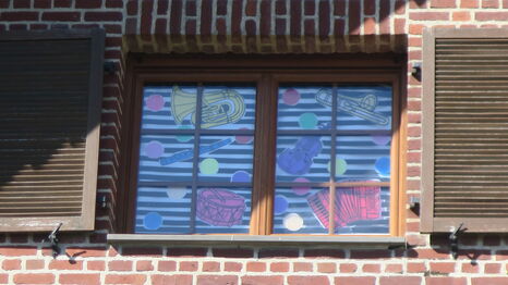 La fenêtre d'un bâtiment de Rombies-et-Marchipont ornée des oeuvres des étudiants de la licence Arts plastiques