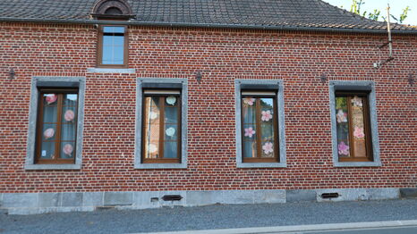 Les fenêtres d'une habitation de Rombies-et-Marchipont ornée des oeuvres des étudiants de la licence Arts plastiques