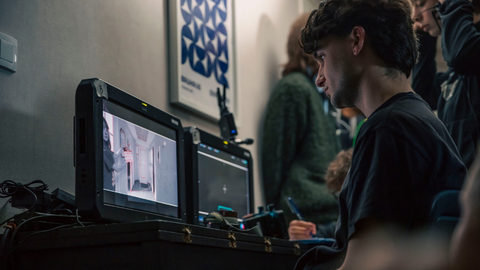 Un jeune homme observe le combo sur un tournage de film
